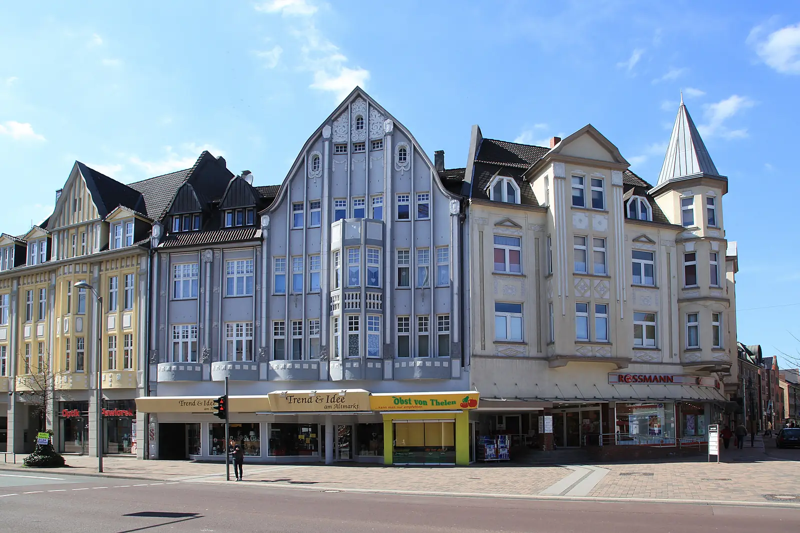 Häuserzeile am Altmarkt in Bottrop mit Giebeln, Erkerturm und Geschäften im Erdgeschoss unter blauem Himmel