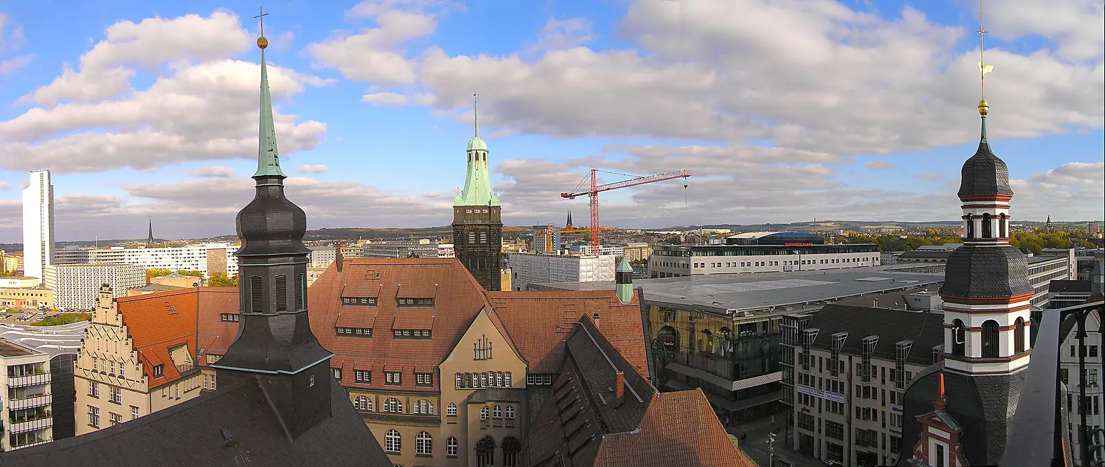 Blick über die Dächer der Chemnitzer Innenstadt mit Turmspitzen, Baukran und Hochhaus