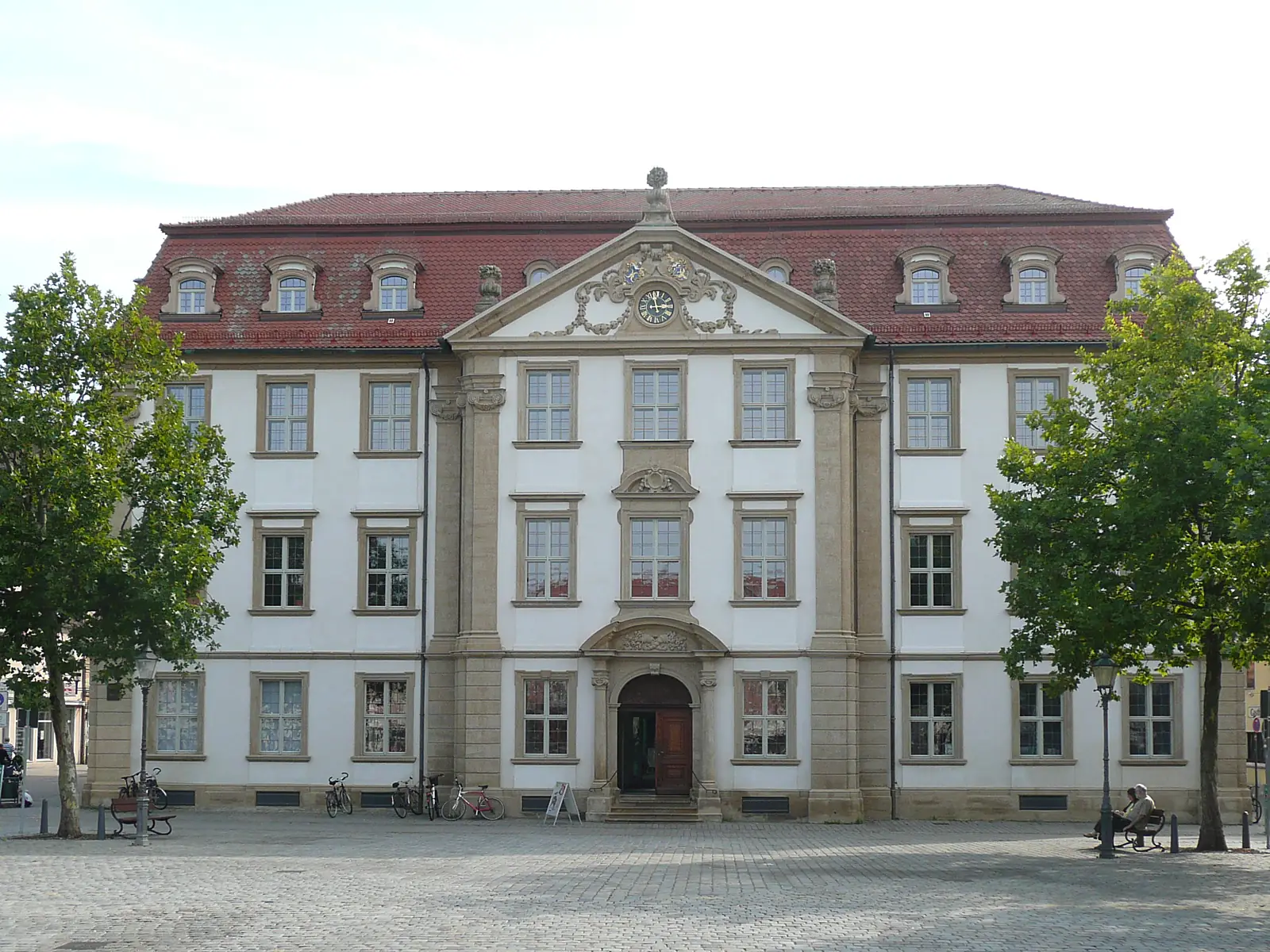 Palais Stutterheim am Marktplatz in Erlangen, ein Barockbau mit rotem Dach und Uhr im Giebel
