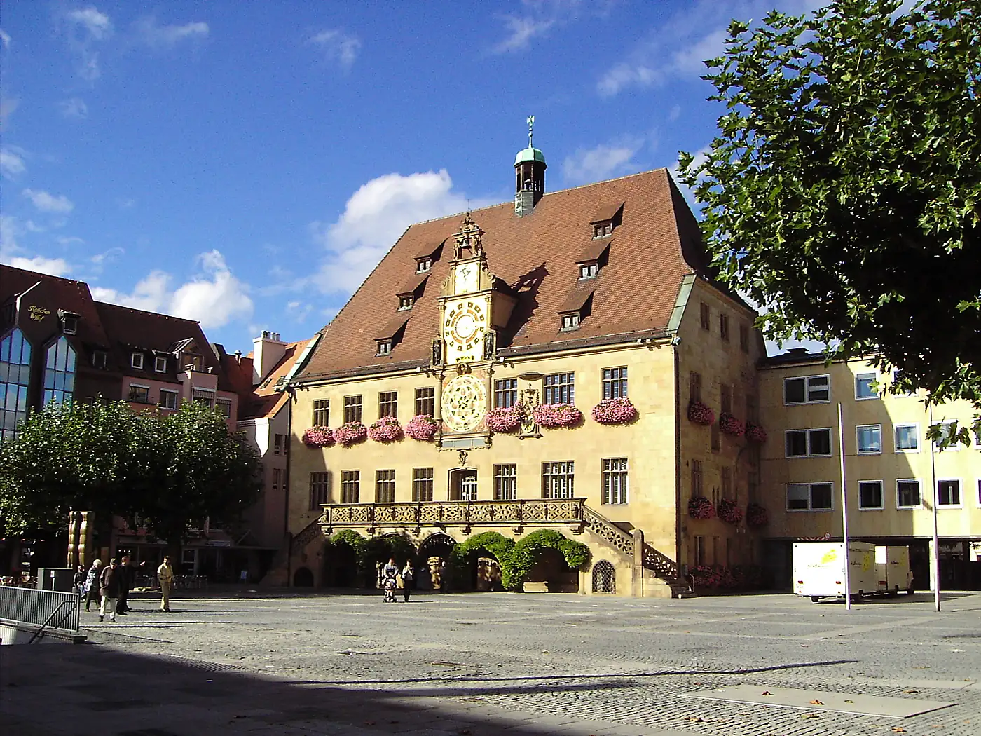 Das Rathaus in Heilbronn mit der Kunstuhr an der Fassade, Blumenkästen und Treppe zum Marktplatz