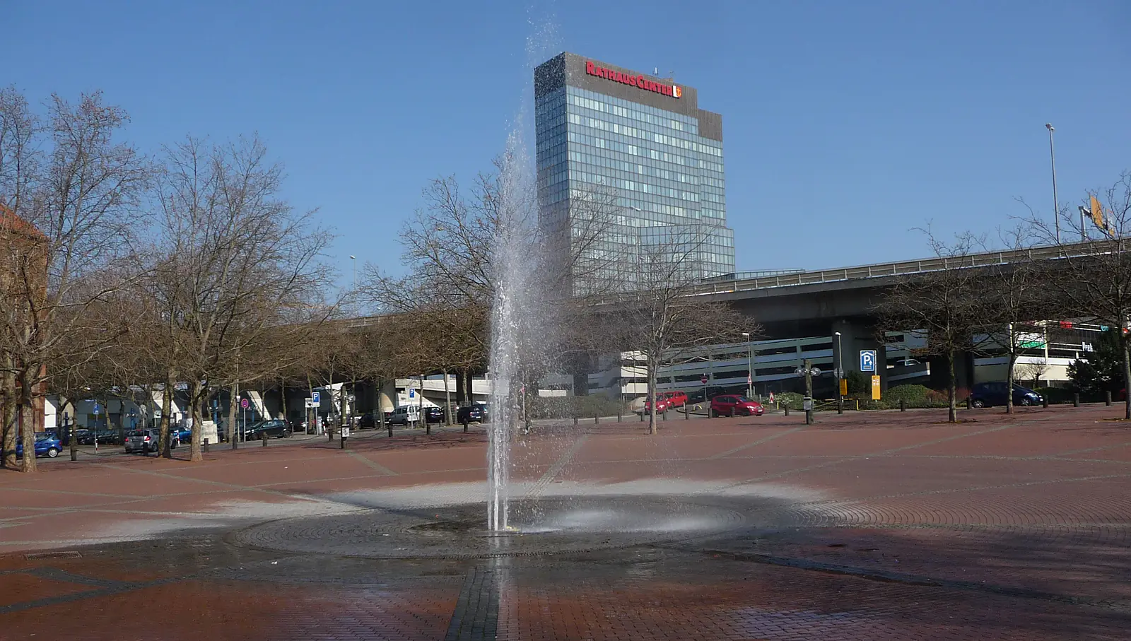 Der Europaplatz in Ludwigshafen mit Springbrunnen, kahlen Bäumen und einem Hochhaus im Hintergrund