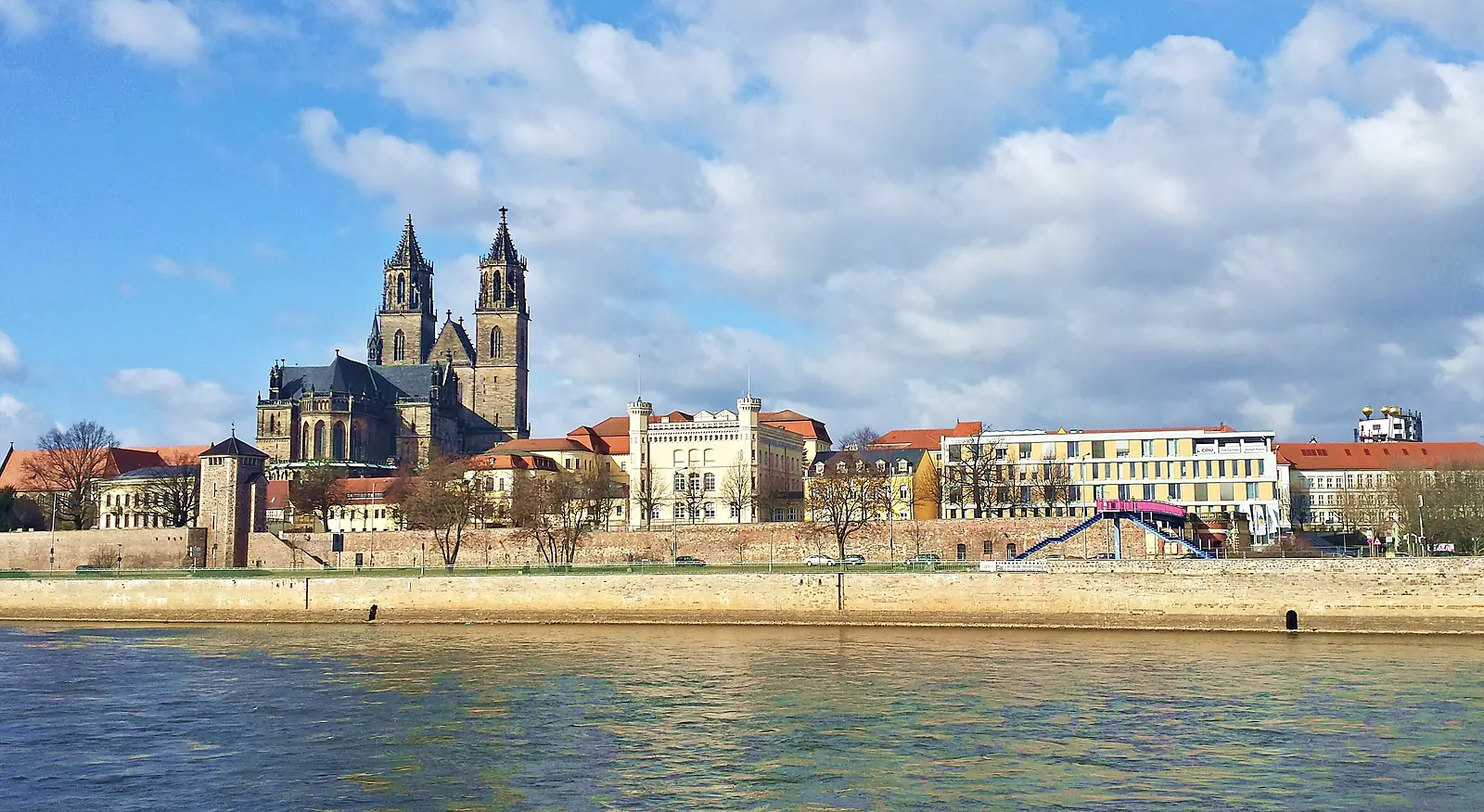 Magdeburger Dom über dem Elbufer mit Ufermauer und Stadtgebäuden