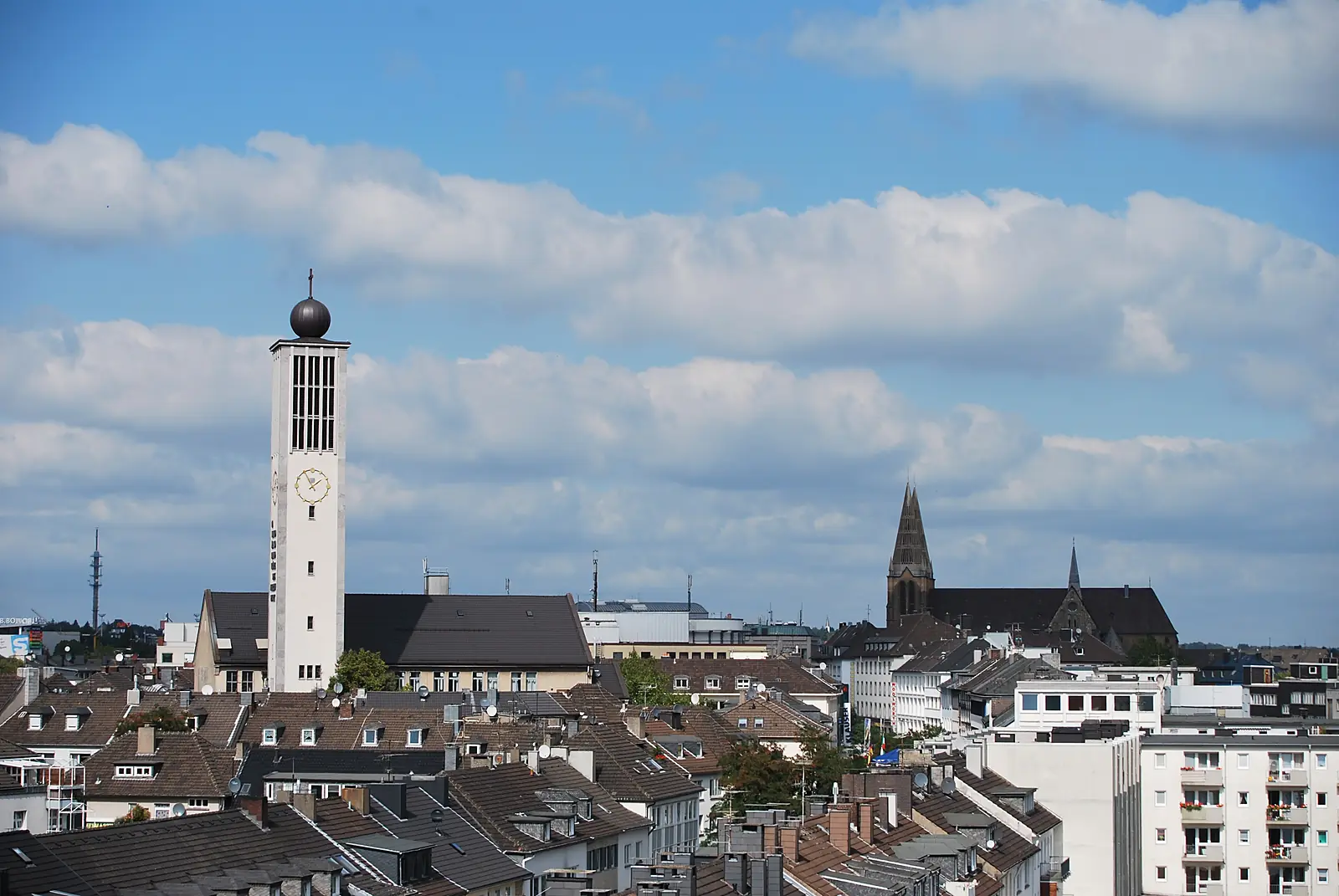 Blick über die Dächer der Solinger Innenstadt mit weißem Kirchturm und einer neugotischen Kirche im Hintergrund